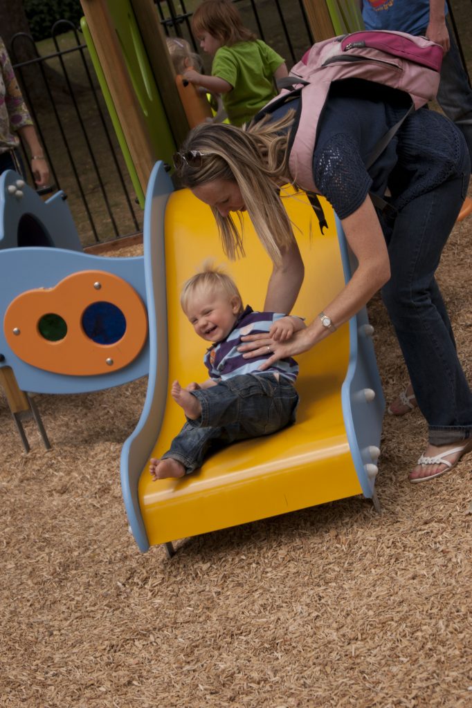 smiling child playing with parent on example of Proludic children's play equipment
