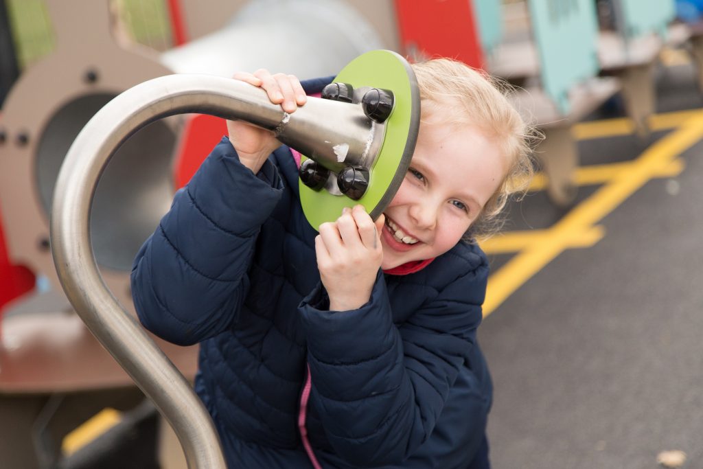 smiling girl playing with Proludic play equipment 2