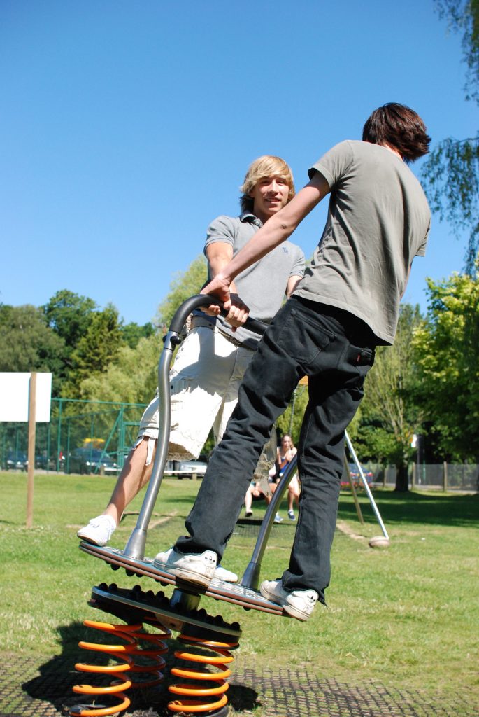 young adults playing on rodeo board example of proludic play equipment available to older children 14+ as part of a healthier lifestyle