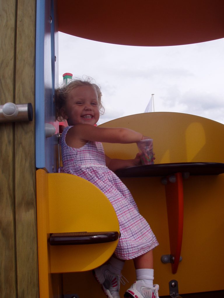 smiling child playing on example of proludic school play equipment