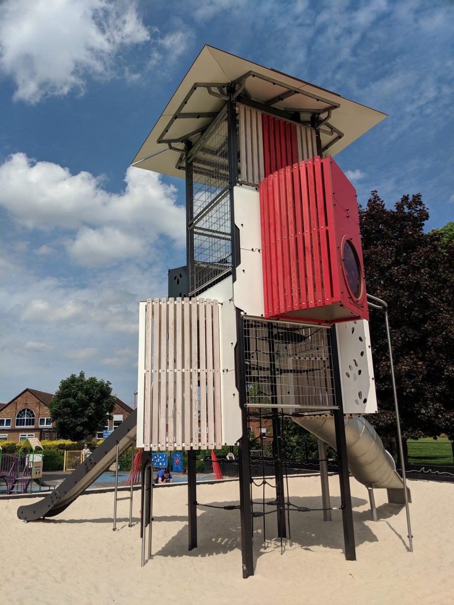 The Taunton lighthouse tower at Victoria Park. A red and white creative play tower with covered metal slide.
